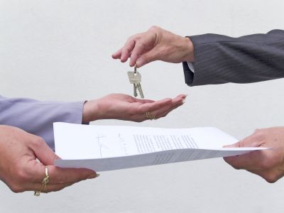 Two people exchaning a contract and a set of keys